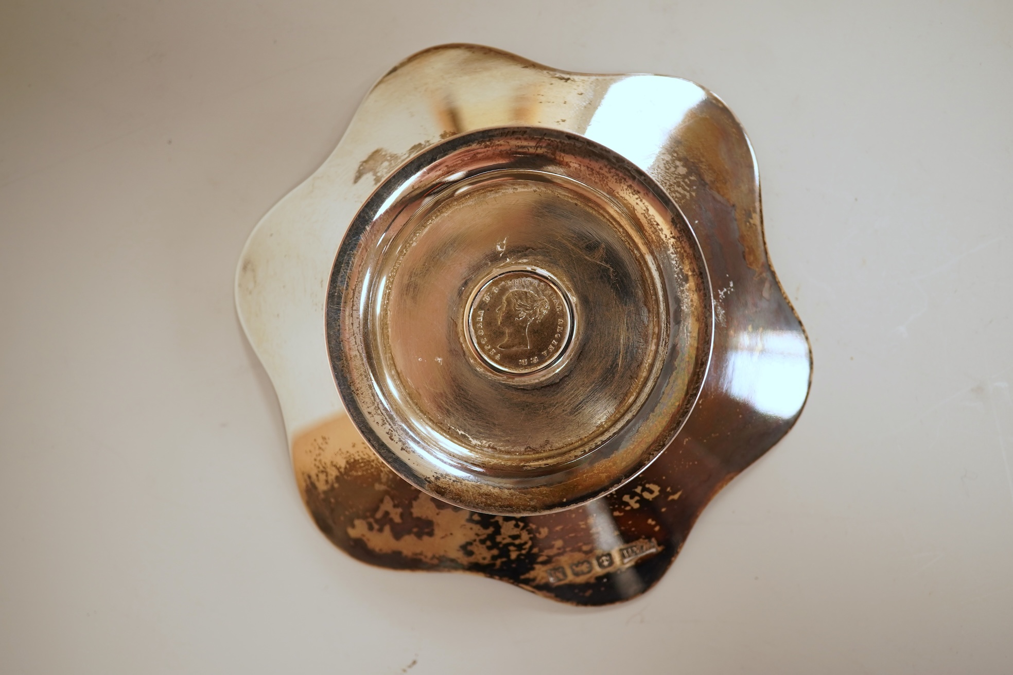 A cased set of four George V silver flower head shaped nut dishes, each inset with an 1850 maundy coin, Walker & Hall, Birmingham, 1936, diameter 77mm.